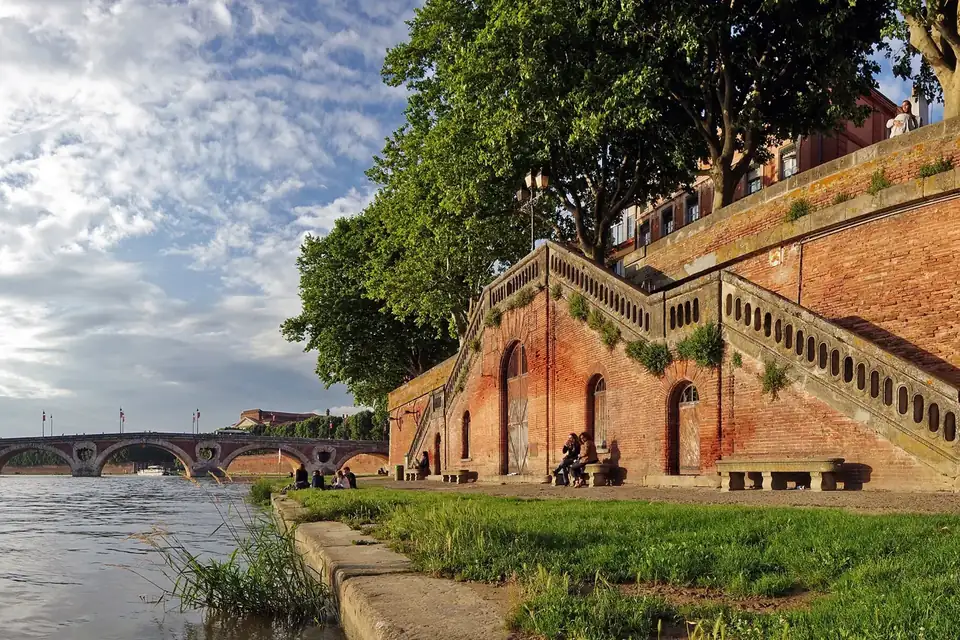 Les quais de briques roses de la Garonne à Toulouse, avec le Pont-Neuf à l'arrière-plan